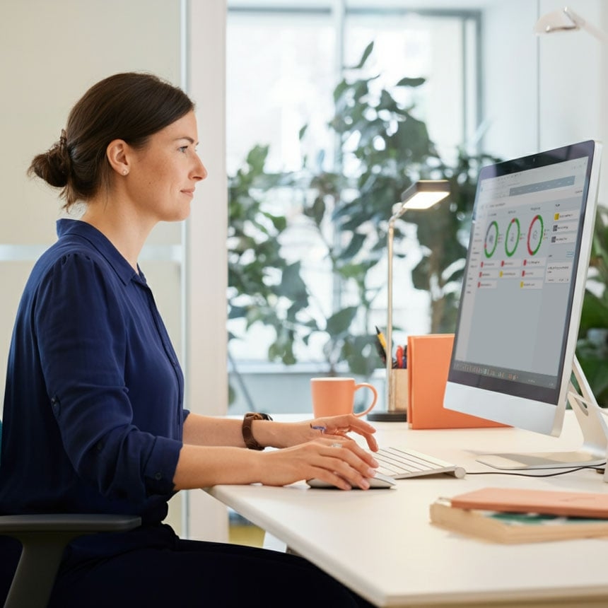 Eine Frau die am Computer sitzt und auf das Dashboard im LearnID System schaut.