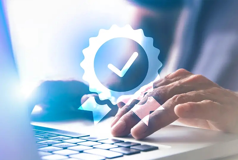 Zertifikatsymbol vor einer Tastatur, auf der jemand tippt