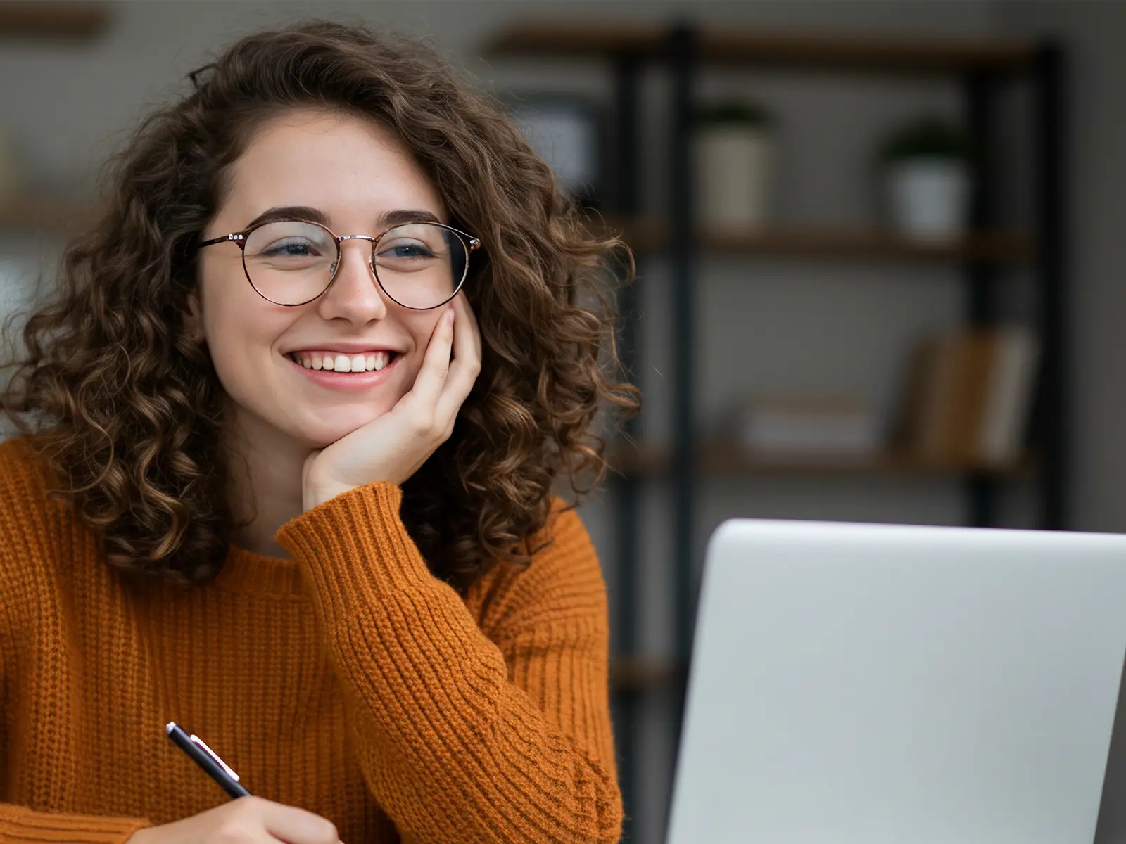 Fröhliche Frau, die an einem Laptop arbeitet